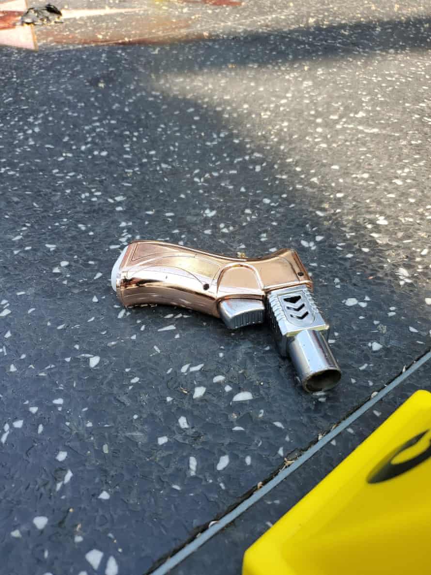 An object with a bronze grip resembling a gun's and a wide cylindrical silver barrel, common on novelty lighters, sits on the terrazzo tile of the Walk of Fame in Hollywood.
