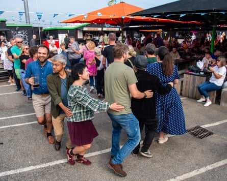 A group of people dance a conga in broad daylight at Wünder Harbour in Folkestone