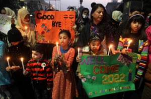 Lahore, Pakistan. Students hold candles during a rally to pray for peace in year 2022.