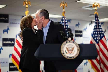 man and woman kiss in front of american flags
