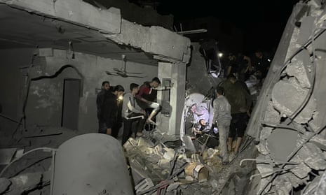 Residents and civil defense teams conduct a search and rescue operation in a demolished building after Israeli attacks in Gaza City on Saturday