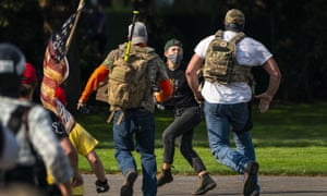 Rightwing demonstrators chase a Black Lives Matter protester after a pro-Trump caravan rally at the Oregon state capitol on 7 September 2020 in Salem.