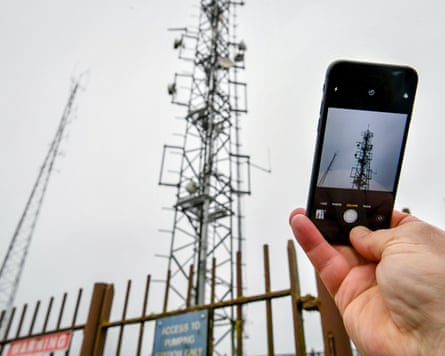 A person stops to take a picture of a mobile phone mast