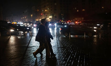 People walk along a dark street without electricity in central Kyiv