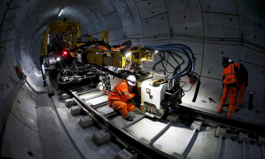 Workers lay railway track in a tunnel of the Crossrail project in east London, November 2016