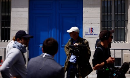 Journalists stand outside the offices, which has a large blue door