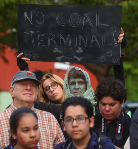 A person holds a sign saying ‘No Coal Terminal’ among a crowd of other people.