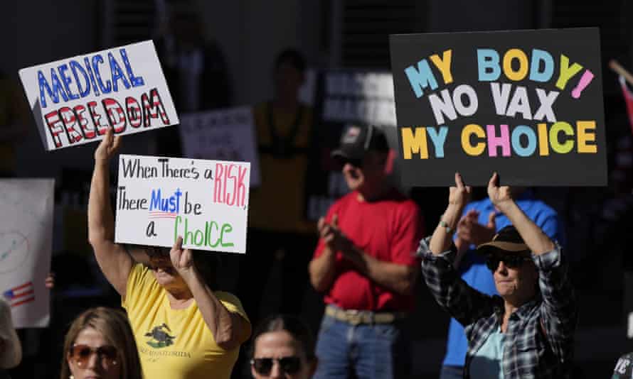 FILE - People hold signs as several hundred anti-mandate demonstrators rally outside the Capitol during a special legislative session considering bills targeting COVID-19 vaccine mandates, Nov. 16, 2021, in Tallahassee, Fla. The vaccines’ first year has been rocky with the disappointment of breakthrough infections, the political strife over mandates and, now, worries about whether the mutant omicron will evade the vaccine’s protection. (AP Photo/Rebecca Blackwell, File)