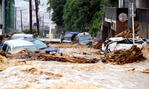 Cars damaged by floodwater as heavy rain continues in Hiroshima, Japan. Dozens of people have been killed.