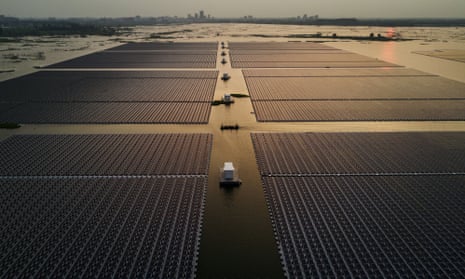Chinese workers ride in a boat through a large floating solar farm project, billed as the largest in the world, under construction on a lake in collapsed and flooded coalmine in Huainan, Anhui province