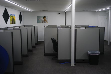 An empty call center office with gray cubicles.