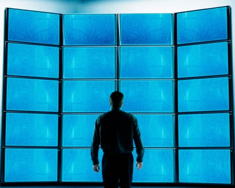 Businessman standing in front of blank television screensGettyImages-71416200