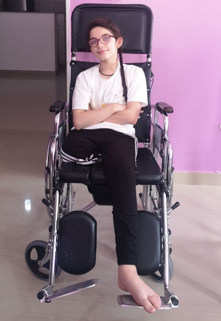 A young girl with one leg in a wheelchair