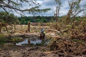 A man on horseback makes his way through a recently flooded area