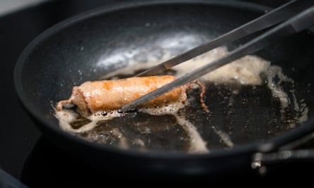 Sausages frying in pan