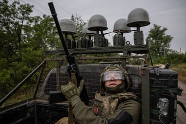A Ukrainian soldier looks up from inside a military vehicle