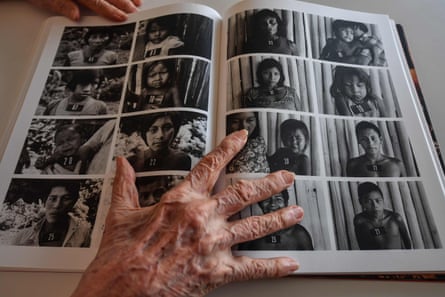 Claudia Andujar keeps a book open on a page with portraits of indigenous people during a press interview in Sao Paulo in 2019.
