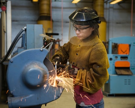 Female welder using machinery