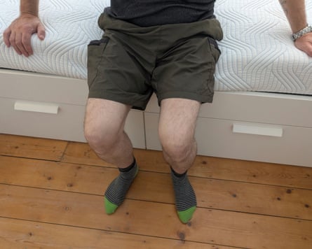 The reviewer’s husband sits at the edge of the Tempur Pro Plus SmartCool mattress testing its edge support.