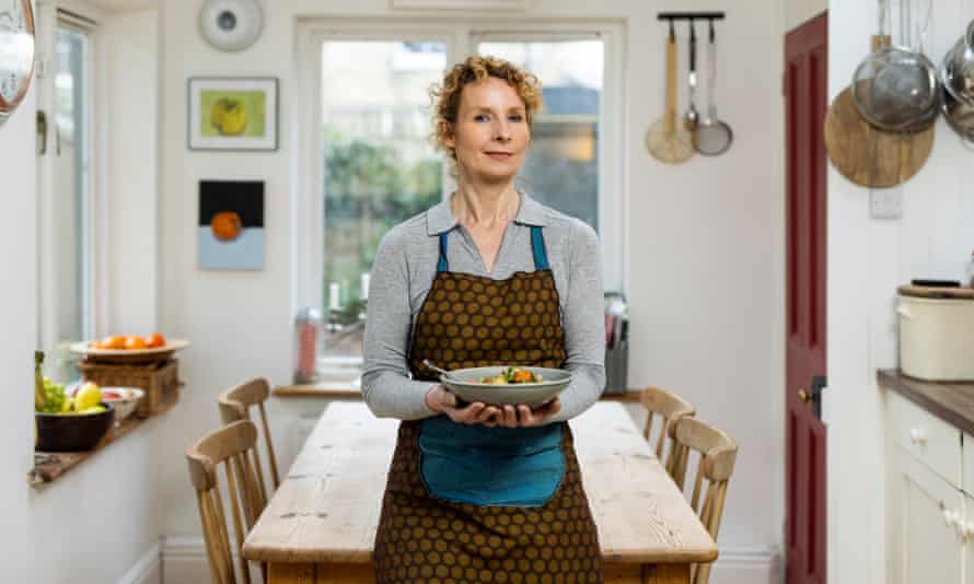 Bee Wilson in kitchen, holding a bowl of chicken stew