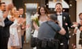 Photographer taking picture of newlywed bride and groom as they leave church.