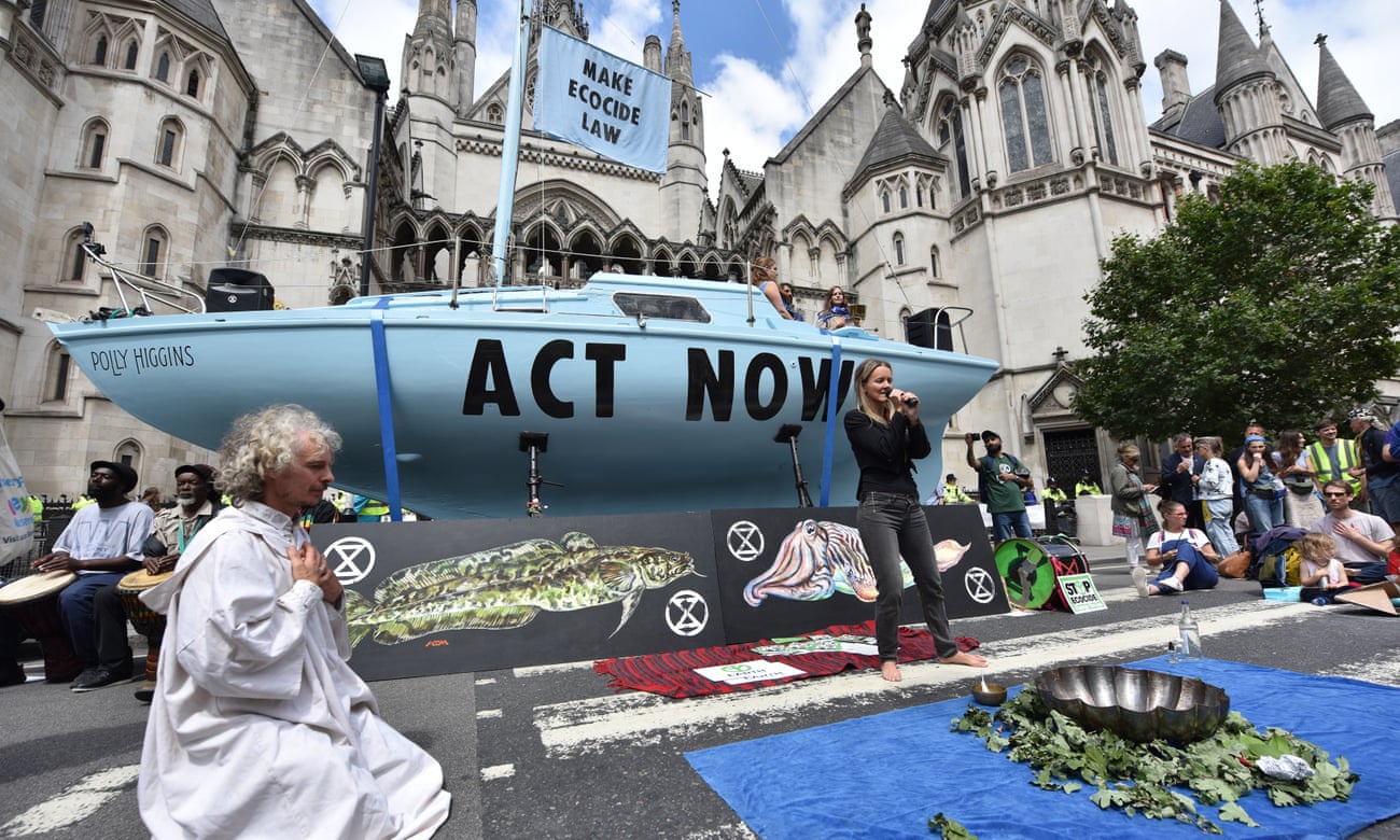 Extinction Rebellion protesters perform a water ceremony, mixing water from all over the country to be poured into the River Thames, outside the royal courts of justice in the Strand, central London.