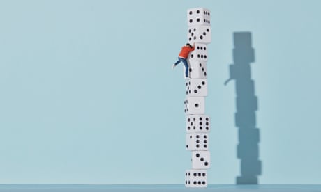 A tiny man climbing up a stack of dice