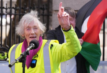 Doolan speaking into a microphone with one hand in the air