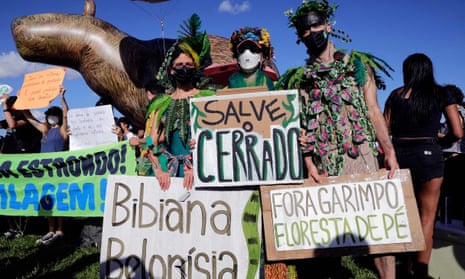 People hold signs during a demo led by Brazilian musician Caetano Veloso (out of frame) against the environmental policies of President Jair Bolsonaro in Brasília.