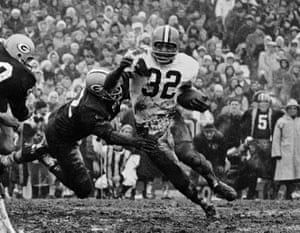 Jim Brown turns the corner as a Green Bay Packer defender swings with him during a football game in Green Bay, Wisconsin, in 1966.