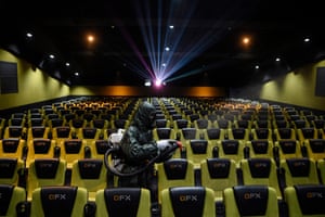A worker sprays disinfectant inside a cinema in Kathmandu, Nepal