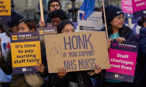 Healthcare workers hold placards at a picket line outside St Thomas’ hospital in London