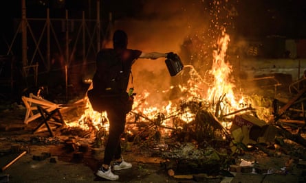 A protester pours petrol on to a burning barricade at the Chinese University of Hong Kong on Tuesday night.