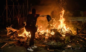 A protester pours petrol onto a burning barricade at the Chinese University of Hong Kong on Tuesday night.