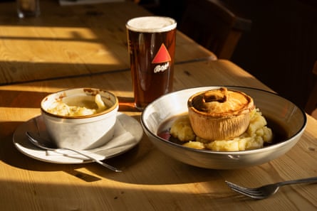 A pie, mash and a pint of ale on a wooden table