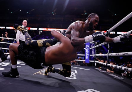 Deontay Wilder and Derek Chisora fall during their fight in London.