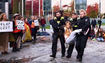 Police officers carry away a Letzte Generation protester in front of the chancellery in Berlin, Germany, October 2023.