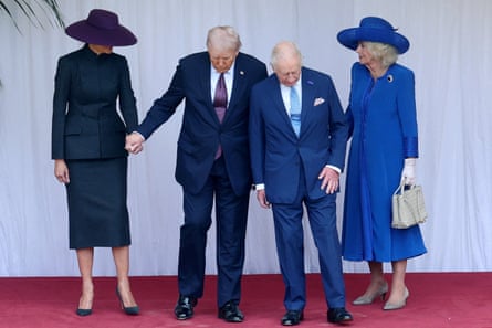two men in suits look down flanked by two women in hats