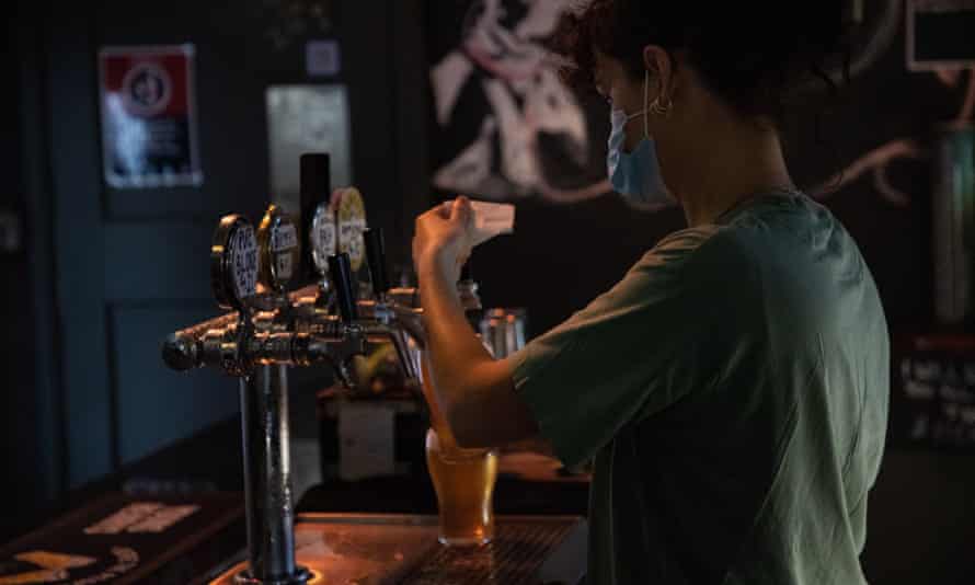 A pub worker pours a beer. The wage rise for award workers in the hospitality sector will be delayed until October.