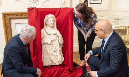 British Museum staff Peter Higgs (left) and Hannah Boulton with Libyan embassy charge d’affaires Mohamed Elkoni view the statue at the Libyan embassy in London.