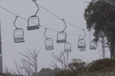 Empty chairs on a ski lift in a foggy sky.