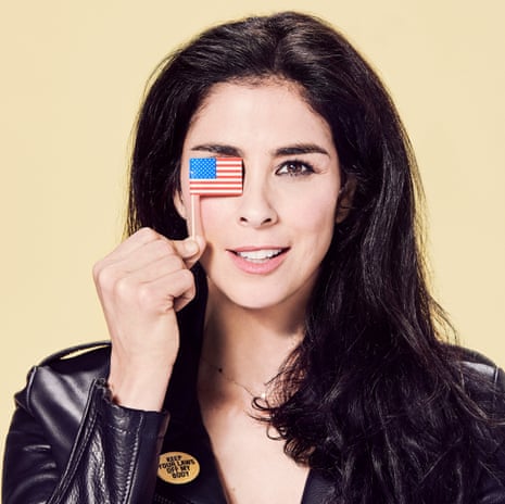 Sarah Silverman wearing a leather jacket and holding a tiny American flag