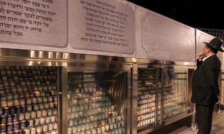 A man stands before candles lit up during a vigil near the Western Wall.