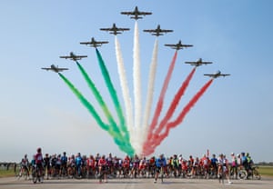 Cyclists wait as the Italian air force acrobatic unit Frecce Tricolori (Tricolour Arrows) perform during the 15th stage of the Giro d’Italia cycling race in Codroipo, Italy