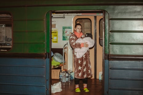 A woman holds her baby in a metro station being used as a bomb shelter in Kharkiv, Ukraine.