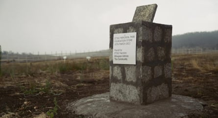 A memorial pillar in a field, with a dedication on a silver plaque to those who died on flight ET 302 and the date.