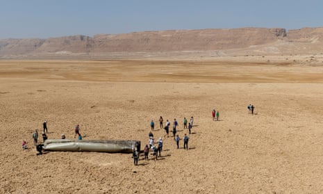 People gather around a component from an intercepted ballistic missile that fell near the Dead Sea in Israel, Saturday, 20 April 2024.