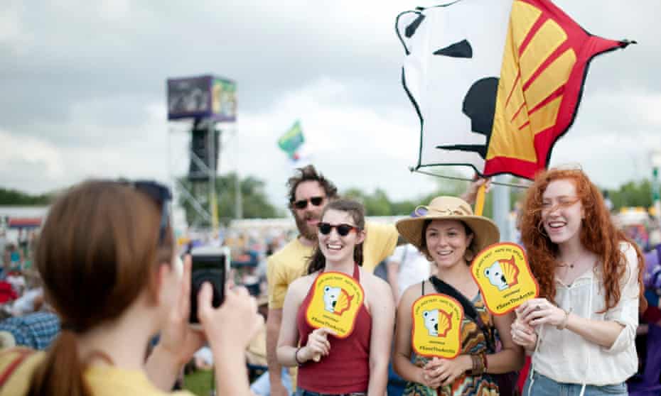 Teenagers pose for a picture under the Shell logo sign at the 45th Louisiana Jazzfest. Greenpeace appeared to protest against the company’s oil drilling project in the north of Alaska. Shell later abandoned the project.