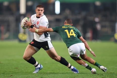 Joe Hawkins of Wales runs with the ball under pressure from Jaco Williams.