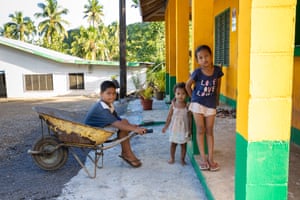 Children play with a wheelbarrow